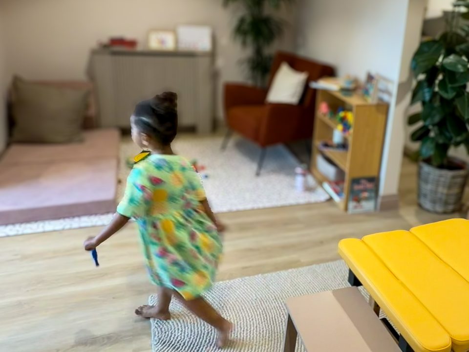 a little girl running across the practice room